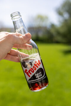 Frostie Root Beer soda bottle isolated hand holding it