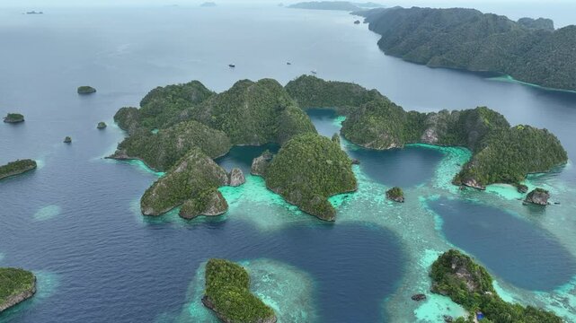 Rock islands rise from the beautiful seascape in Misool, Raja Ampat, Indonesia. This area is known as the heart of marine biodiversity and is a popular destination for diving and snorkeling.