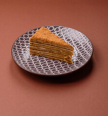 A slice of honey puff cake or pumpkin, carrot and cream pie, vegan sweets