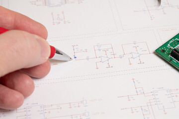 Engineer reviewing electronic schematic diagram
