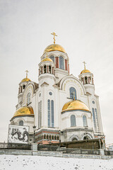 Fototapeta premium A large white church on the blood in Yekaterenburg Ural Russia with gold domes and crosses on top
