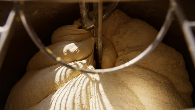 Professional bakery dough mixing detailed close-up of the kneading process in an industrial mixer, essential for fresh bread and baked goods. High quality 4k footage