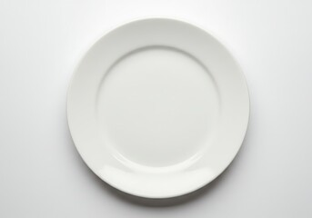 A simple white plate centered on a white background in a studio setting with soft lighting effect
