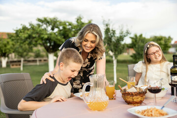 The son is not thrilled with the food his mom brought him during a family dinner in nature.