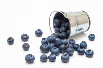 A bucket of ripe blueberries on a white background.