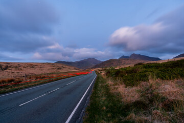 Car driving on scenic road at twilight in Snowdonia National Park