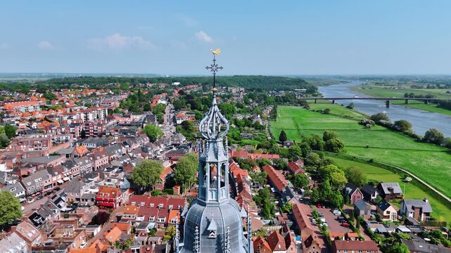 Rising over the top of the Cunera Church revealing view on the beautiful scenery of city of Rhenen, Province Utrecht, the Netherlands. Bridge over the river at backdrop.