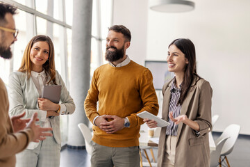 Group of executives standing at boardroom at corporate office and discussing business plan.