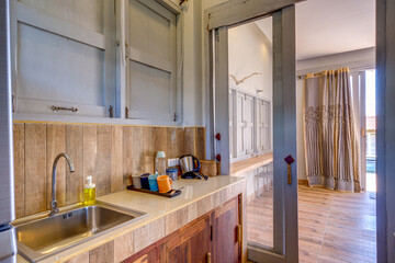 Koh Yao Yai, Thailand - February 5 2025: Rustic Kitchen Interior With Brick Walls and Modern Amenities in Sunlit Room