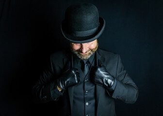 Vintage British Crime or Mafia Boss in Black Suit and Bowler Hat and Leather Gloves. Back Alley Ruffian and Criminal Mastermind.