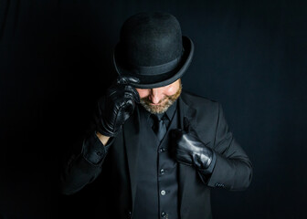 Vintage British Mob Boss or Classic Criminal in Dark Suit and Bowler Hat and Leather Gloves. Back Alley Ruffian and Cool Hooligan