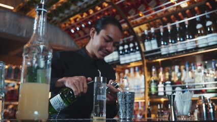 Asian bartender pouring mixed cocktail juice liqueur all ingredient into sliver shaker alcohol drink, making special advertisement creative tasty, focused refreshing showcase at bar luxury. Vinosity.