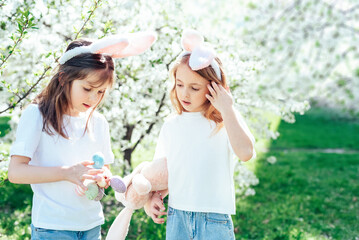 Easter egg hunt. Group Of Children Wearing Bunny Ears Running To Pick Up colorful Egg On Easter Egg Hunt In Garden. Easter tradition. Laughing children in park with basket spring concept