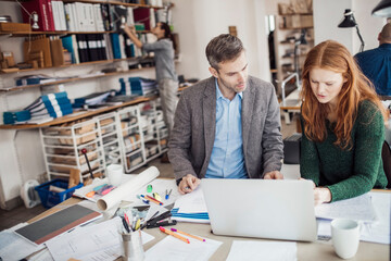 Young man and woman working together on a project in a startup company office