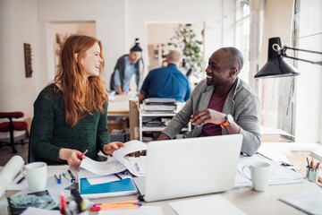 Young man and woman working together on a project in a startup company office