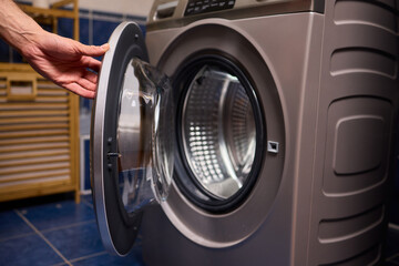 A contemporary modern washing machine with its door open, showcasing laundry inside
