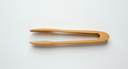 Beige wooden tongs on white background