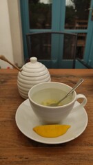 Warm cup of herbal tea with fresh lemon slice on rustic wooden table, cozy atmosphere inviting relaxation and mindfulness during peaceful moments of self-care