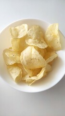 Crispy golden potato chips piled in a white bowl with a light seasoning, perfect snack for gatherings or casual moments of indulgence and enjoyment