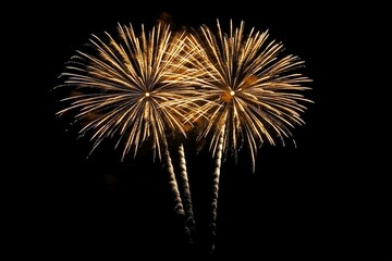 Obraz premium Golden fireworks in the dark sky with festive bokeh. New year celebration concept