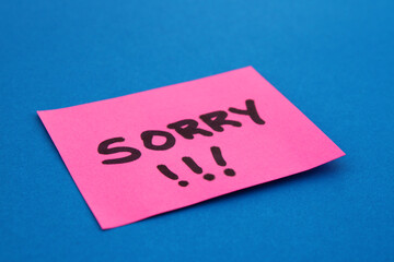 Sticky note with the word SORRY and exclamation points