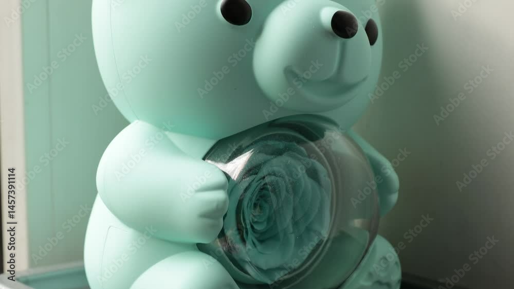 Poster close-up view of a small toy bear sitting on a window sill, perfect for decorating a nursery or play