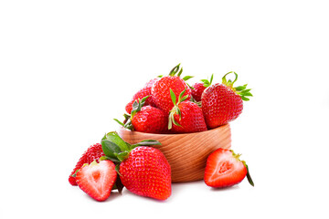 Fresh ripe strawberries in a wooden bowl on white background. Whole and cut strawberries. Healthy summer fruit. Close-up.
