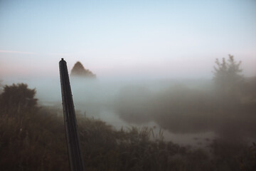 Hunting shotgun barrel aiming during foggy morning on river bank during hunting season as hunting...