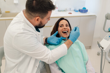 Dentist examining patient's teeth in modern dental clinic