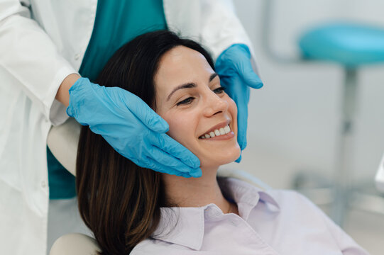 Doctor examining patient face skin in medical clinic