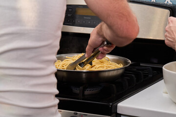 Cooking Spaghetti Pasta on Stove with Sauce Preparation
