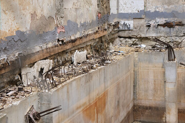Abandoned building site with rusty metal and crumbling concrete walls