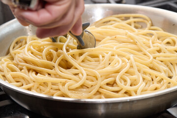 Cooking Spaghetti Pasta on Stove with Sauce Preparation
