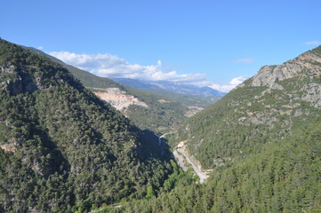 Panoramic Mountain Valley View with Pine Forest and Blue Sky