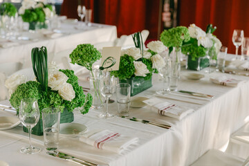 Elegant table setting with floral arrangements at a sophisticated event in a modern venue during daytime