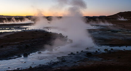Dramatic Geothermal Landscape At Sunset With Rising Steam And Water
