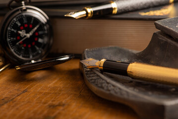 Naklejka premium Fountain pen, two beautiful fountain pens with books on a rustic wooden surface, selective focus.