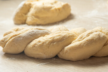 Raw homemade bread, preparing and kneading the bread before baking, on a wooden surface, selective focus.