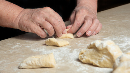 Raw homemade bread, preparing and kneading the bread before baking, on a wooden surface, selective focus.
