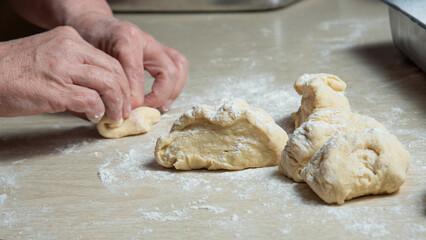 Raw homemade bread, preparing and kneading the bread before baking, on a wooden surface, selective focus.