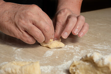 Raw homemade bread, preparing and kneading the bread before baking, on a wooden surface, selective focus.