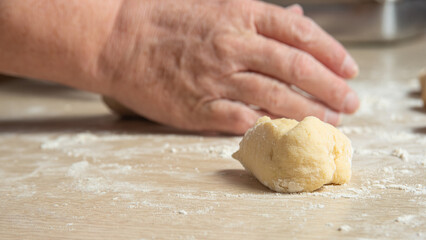 Raw homemade bread, preparing and kneading the bread before baking, on a wooden surface, selective focus.