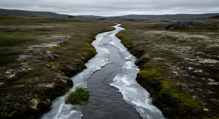 Icy River Flowing Through A Barren Landscape Under A Cloudy Sky