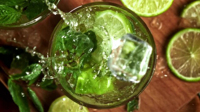Ice falls into a mojito cocktail. Filmed on a high-speed camera at 1000 fps. High quality FullHD footage