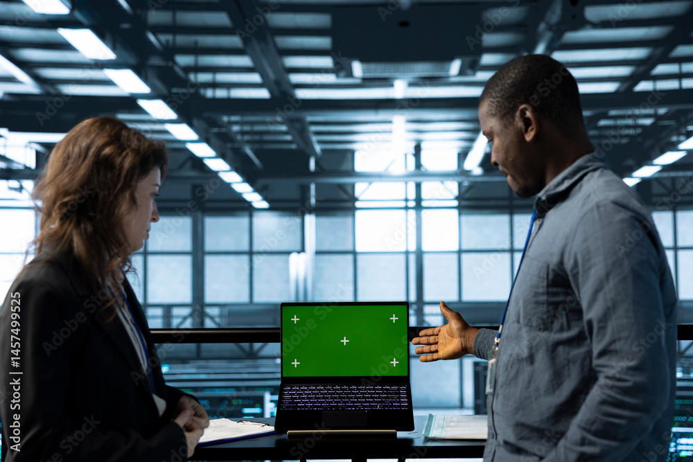 Poster engineers in data center using green screen mockup laptop to develop disaster recovery plans. it exp