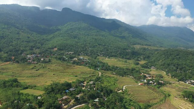Breathtaking view of rice paddies and villages nestled amidst the lush green mountains of Pu Luong, Vietnam