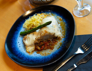 Baked cod fillet on vegetable ratatouille with chorizo, crisp shoestring fries, asparagus and...