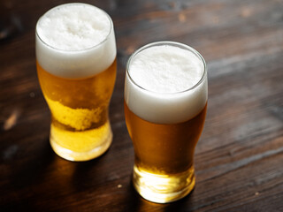 Two glasses of light refreshing beer on a wooden table