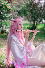 Deer dryad girl against the background of a blooming pink apple tree