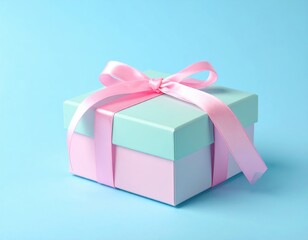 Fototapeta premium A pastel teal gift box tied with a pink ribbon rests on a bright blue surface, evoking a joyful and celebratory mood.